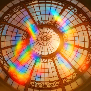 Jigsaw puzzle: An ornate glass dome ceiling with a bright rainbow reflection arcing across its surface.